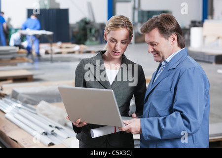 Deutschland, Neukirch, Architektin und Vorarbeiter in Industriehalle Stockfoto