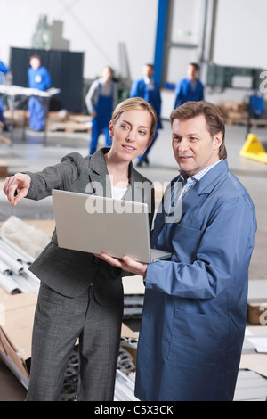 Deutschland, Neukirch, Architektin und Vorarbeiter in Industriehalle Stockfoto