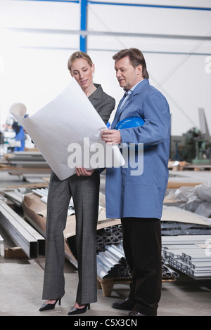 Deutschland, Neukirch, Architektin und Vorarbeiter in Industriehalle Stockfoto