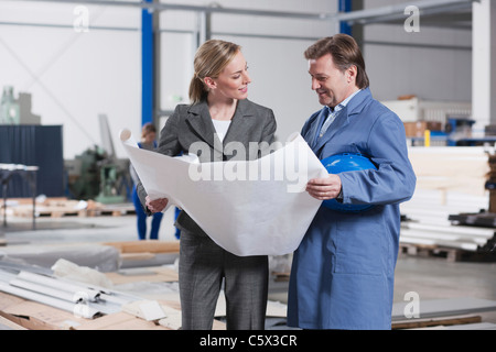 Deutschland, Neukirch, Architektin und Vorarbeiter in Industriehalle Stockfoto