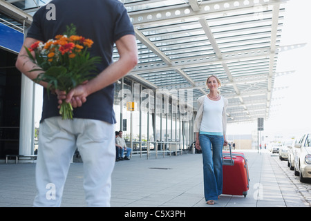 Deutschland, Leipzig-Halle, Flughafen, Frau mit Koffer, Mann, hält Blumen Stockfoto