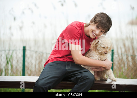 Deutschland, Bayern, Ammersee, junger Mann und Hund auf Bank, Porträt Stockfoto