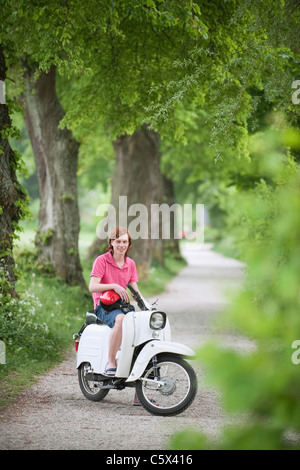 Deutschland, Bayern, junger Mann auf dem Moped, Lächeln, Porträt Stockfoto