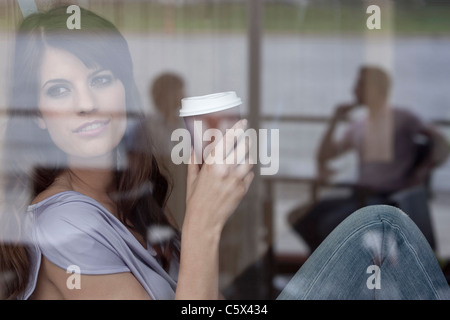 Deutschland, Köln, junge Frau im Fenster des café Stockfoto