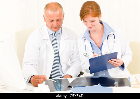 Ärzteteam senior Mann mit weiblichen Arzt Konsultation über x-ray Stockfoto