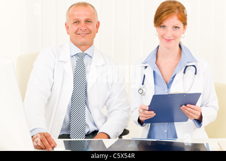 Ärzteteam senior Mann mit weiblichen Arzt schauen in die Kamera Stockfoto