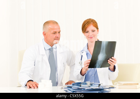 Ärzteteam senior Mann mit junge Ärztin schauen x-ray Stockfoto