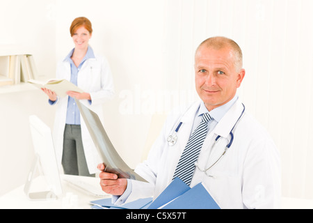 Arzt Team senior woman mit Krankenschwester halten Röntgen Stockfoto