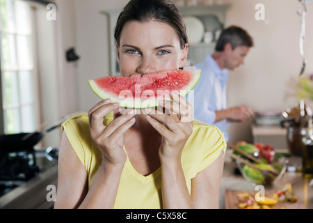Deutschland, Hamburg, paar in Küche, Frau mit Melone slice Stockfoto