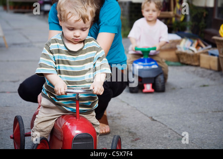 Deutschland, Berlin, Mutter und junge (2-3) (3-4) auf Spielzeug-Traktor, close-up Stockfoto