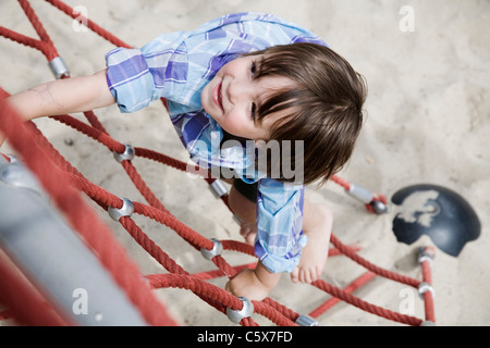 Deutschland, Berlin, Boy (3-4) auf Spielplatz Klettern am Klettergerüst, erhöht, Ansicht Stockfoto