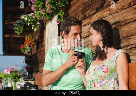 Italien, Südtirol, paar vor Blockhütte mit Weingläsern, Lächeln, Porträt Stockfoto