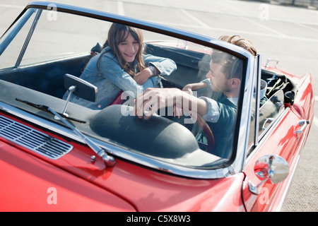 Deutschland, Berlin, junges Paar sitzt im Cabriolet, Lächeln, Porträt Stockfoto