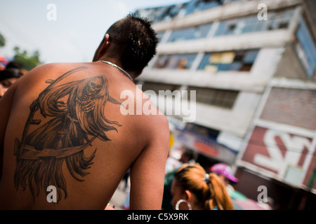 Ein mexikanischer Anhänger der Santa Muerte (Tod der Heiligen) zeigt seine Tätowierung während der Prozession in Tepito, Mexico City, Mexiko. Stockfoto