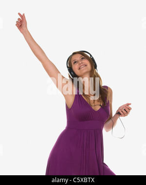 Junge Frau mit Kopfhörern anhören von MP3-Player, Porträt Stockfoto