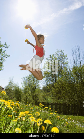 Österreich, Salzkammergut, Mädchen (10-11) springen in Garten, Seitenansicht Stockfoto