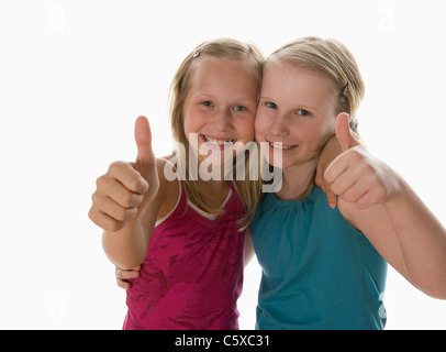 Zwei Mädchen (10-11) Daumen hoch, Lächeln, Porträt Stockfoto