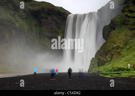 Touristen unterhalb von 200ft (61m) hohen Skogafoss Wasserfall Skogar Island Stockfoto