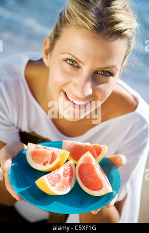 junge gesunde Frau mit Platte von rosa grapefruit Stockfoto
