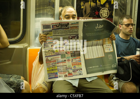 Ein Pendler liest der Urdu Zeiten in der u-Bahn auf Sonntag, 24. Juli 2011 (© Frances M. Roberts) Stockfoto