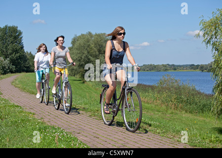 drei Mädchen, Radfahren auf dem Deich neben See Gartow, Nature Reserve Elbufer-Drawehn, Niedersachsen Stockfoto