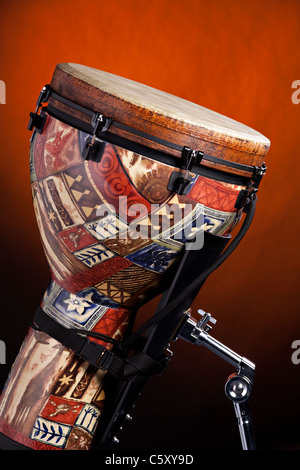 Eine afrikanische oder Latein Djembe Trommel vor dem Rampenlicht gold Hintergrund isoliert. Stockfoto