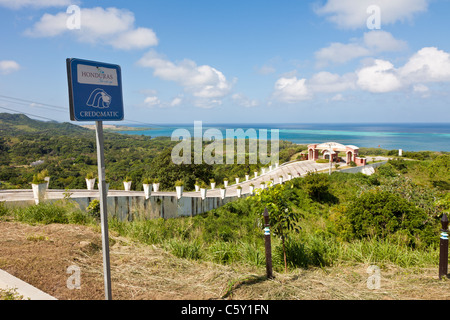 Credomatic Bank Schild nahe Einfahrt zum resort mit Blick auf karibische Meer auf der Insel Roatan, Honduras Stockfoto