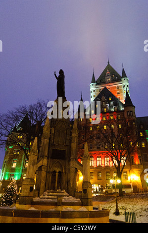 QUÉBEC STADT, Kanada – das majestätische Fairmont Le Château Frontenac, beleuchtet gegen den Nachthimmel, thront über der Altstadt von Québec. Die märchenhaften Türme und steilen Kupferdächer, die mit Schnee bedeckt sind, schaffen eine magische Winterszene in diesem historischen UNESCO-Weltkulturerbe. Stockfoto