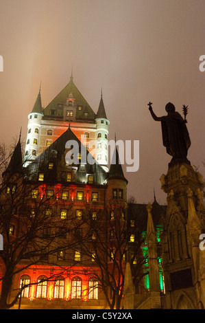 QUÉBEC STADT, Kanada – das majestätische Fairmont Le Château Frontenac, beleuchtet gegen den Nachthimmel, thront über der Altstadt von Québec. Die märchenhaften Türme und steilen Kupferdächer, die mit Schnee bedeckt sind, schaffen eine magische Winterszene in diesem historischen UNESCO-Weltkulturerbe. Stockfoto