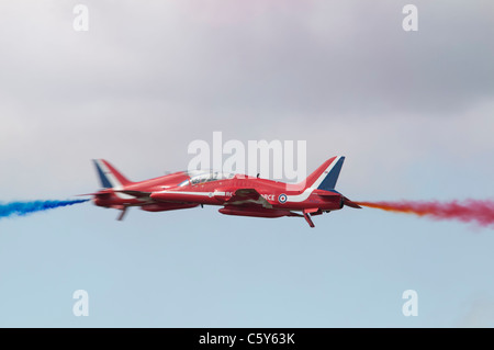 Zwei britische Hawk T1-Militär-Jets von der Royal Air Force Red Arrows aerobatic Anzeige Mannschaft durchführen ihre gefährlichen Kopf-an-Kopf-Kreuz über Stockfoto