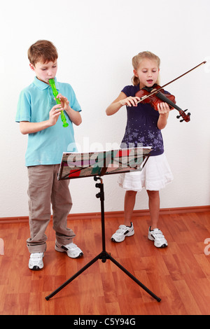 Cute kids spielen Querflöte und Violine zusammen Stockfoto