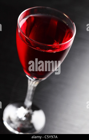 Glas Rotwein auf schwarzem Hintergrund Stockfoto