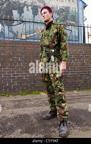 Jugend verkleidet als Soldat vom 3. Fallschirm-Regiment während einer Protest-Parade vor einem republikanischen Wandgemälde steht. Stockfoto