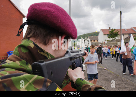 Jugend verkleidet als eines britischen Soldaten von den Fallschirm-Regiment Punkten eine Replikat Gewehr auf eine Gruppe von republikanischen Demonstranten Stockfoto