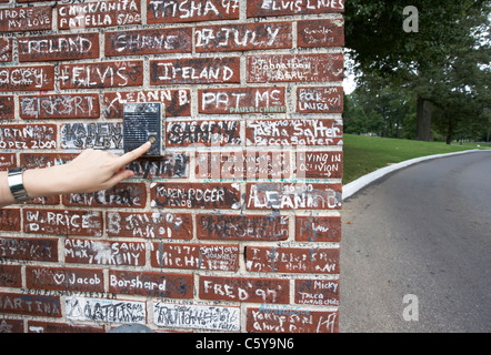 Womans Hand alte Sprechanlage drücken auf Wand bedeckt Graffiti außerhalb Graceland Memphis Tennessee usa Stockfoto