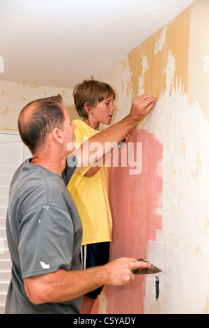 California kaukasischen Vater und Sohn 11 Jahre Jahre alt zusammenarbeiten, um die Tapete von der Wand zu entfernen. Herr © 2011 Myrleen Pearson Stockfoto