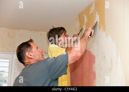 Kaukasische Vater und 11. / 12. Jahr Jahre alten Sohn helfen, arbeiten zusammen, um Tapete von der Wand zu entfernen. Herr © 2011 Myrleen Pearson Stockfoto