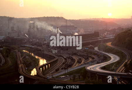 Rauch steigt vom Stahlwerk bei Sonnenuntergang am Fluss im Monongahela Valley East Pittsburgh Braddock Anfang der 1970er Jahre Stockfoto