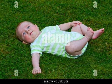 Fünf Monate alten Baby junge auf dem Rasen liegen Stockfoto