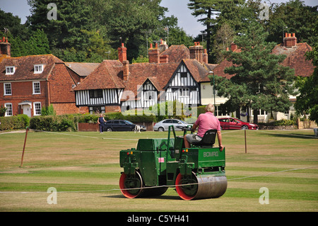 Man Rolling Cricket-Feld auf der Green, Bearsted, Kent, England, Vereinigtes Königreich