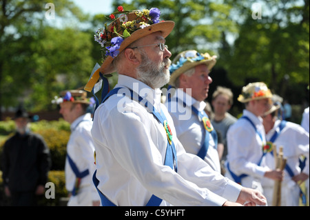 Eine Gruppe von traditionellen englischen Morris Tänzer tragen weiße Hemden und Strohhüte bedeckt Frühlingsblumen überspringen Stockfoto
