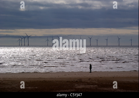 'Another Place', Antony Gormleys Statuen am Crosby Beach, Liverpool, Merseyside, England, Windpark Burbo Bank im Hintergrund Stockfoto