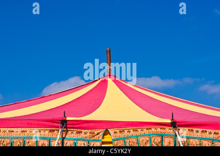 Einen bunten Zirkus Zelt oben gegen ein strahlend blauer Himmel Stockfoto