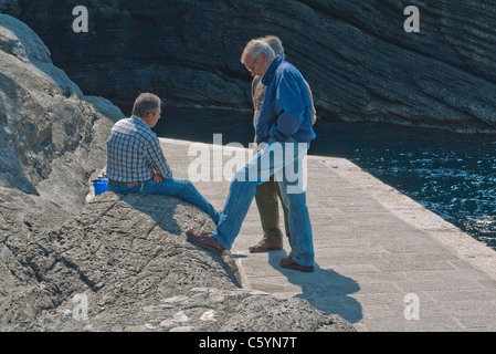 Drei italienische Senioren versammeln, um am Hafen in Vernazza, Cinque Terre, Italien zu sprechen. Stockfoto