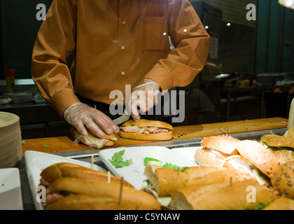 Kochen Sie Vorbereitung Sandwiches hinter Cafeteria Theke Stockfoto