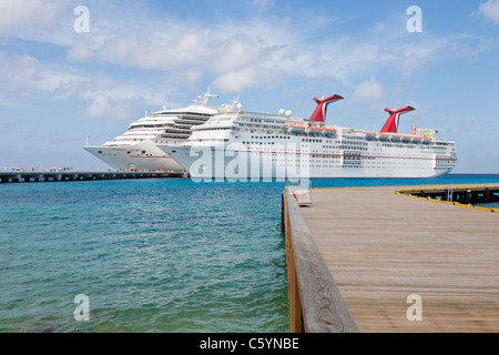 Kreuzfahrtschiffen Sie Passagiere von auf Pier Aussteigen aus Karneval Kreuzfahrt-Schiffe, Triumph und Ekstase in Cozumel, Mexiko Stockfoto