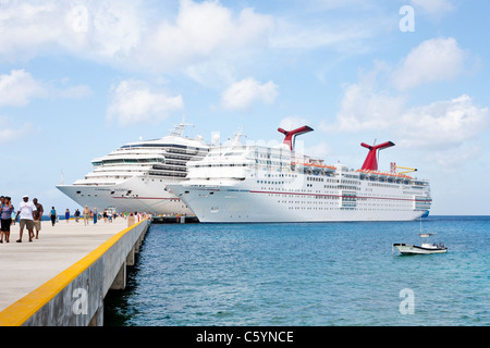 Kreuzfahrtschiffen Sie Passagiere von auf Pier Aussteigen aus Karneval Kreuzfahrt-Schiffe, Triumph und Ekstase in Cozumel, Mexiko Stockfoto