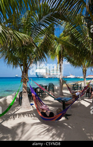 Touristen entspannen Sie in Hängematten am Strand von Cozumel, Mexiko im karibischen Meer Stockfoto