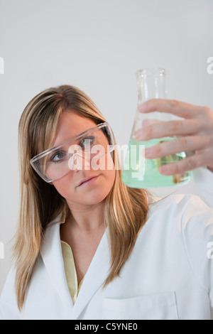 USA, Illinois, Metamora, Nahaufnahme von Frau mit Schutzbrille holding Laborglas Stockfoto