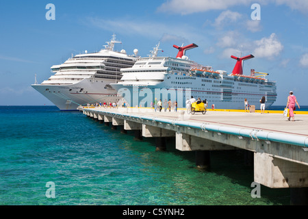 Kreuzfahrtschiffen Sie Passagiere von auf Pier Aussteigen aus Karneval Kreuzfahrt-Schiffe, Triumph und Ekstase in Cozumel, Mexiko Stockfoto